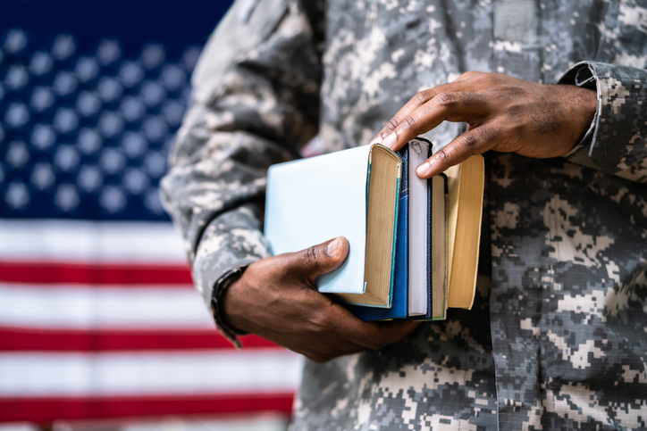 Military man holding books