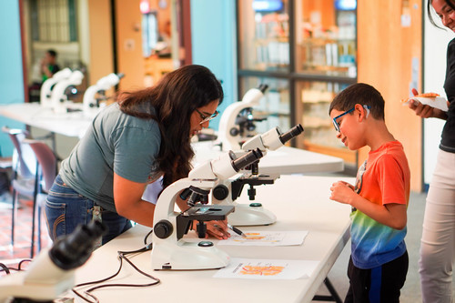 teacher showing a student a microscope